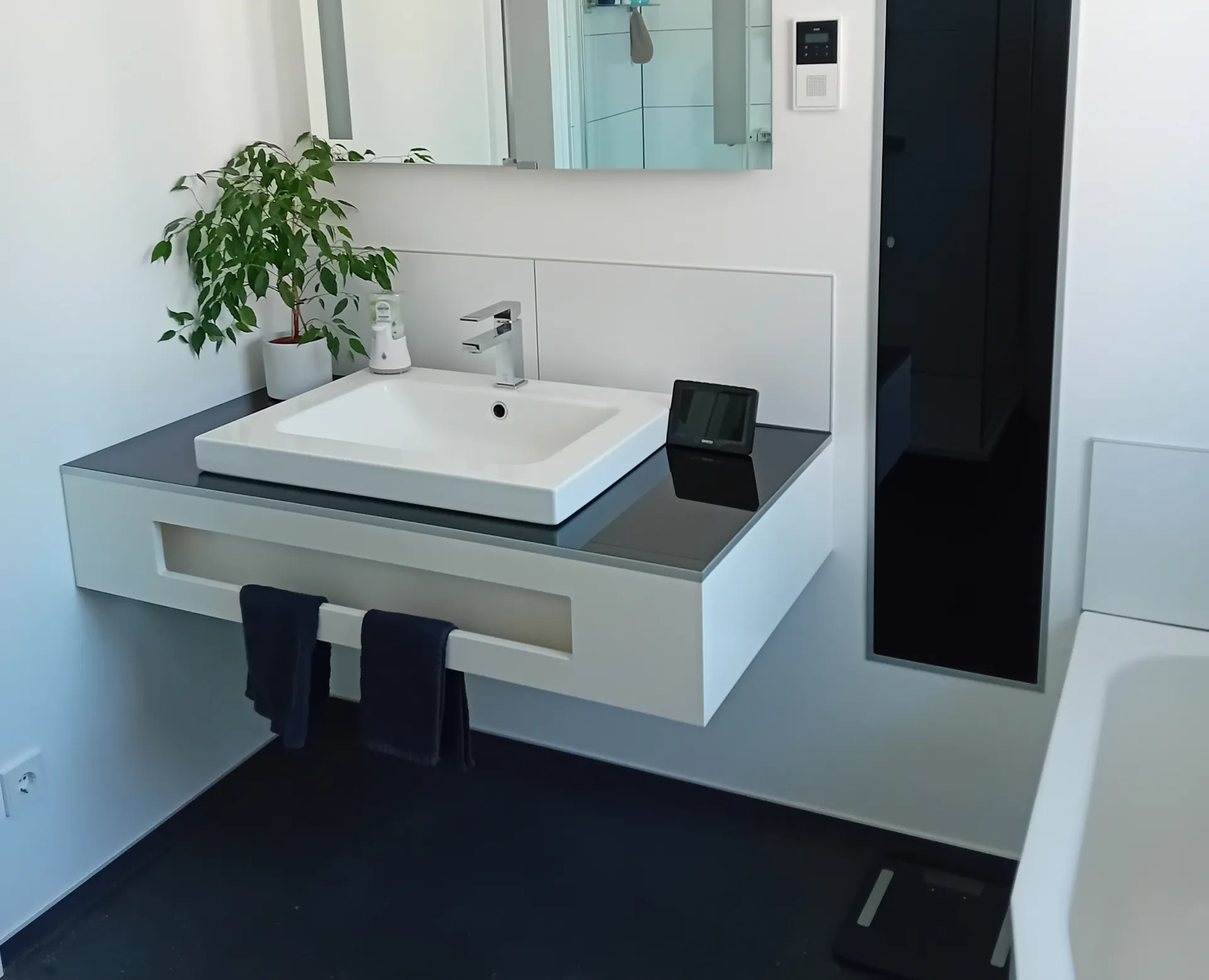 Schwarz lackierte Ablagefläche neben Waschtisch