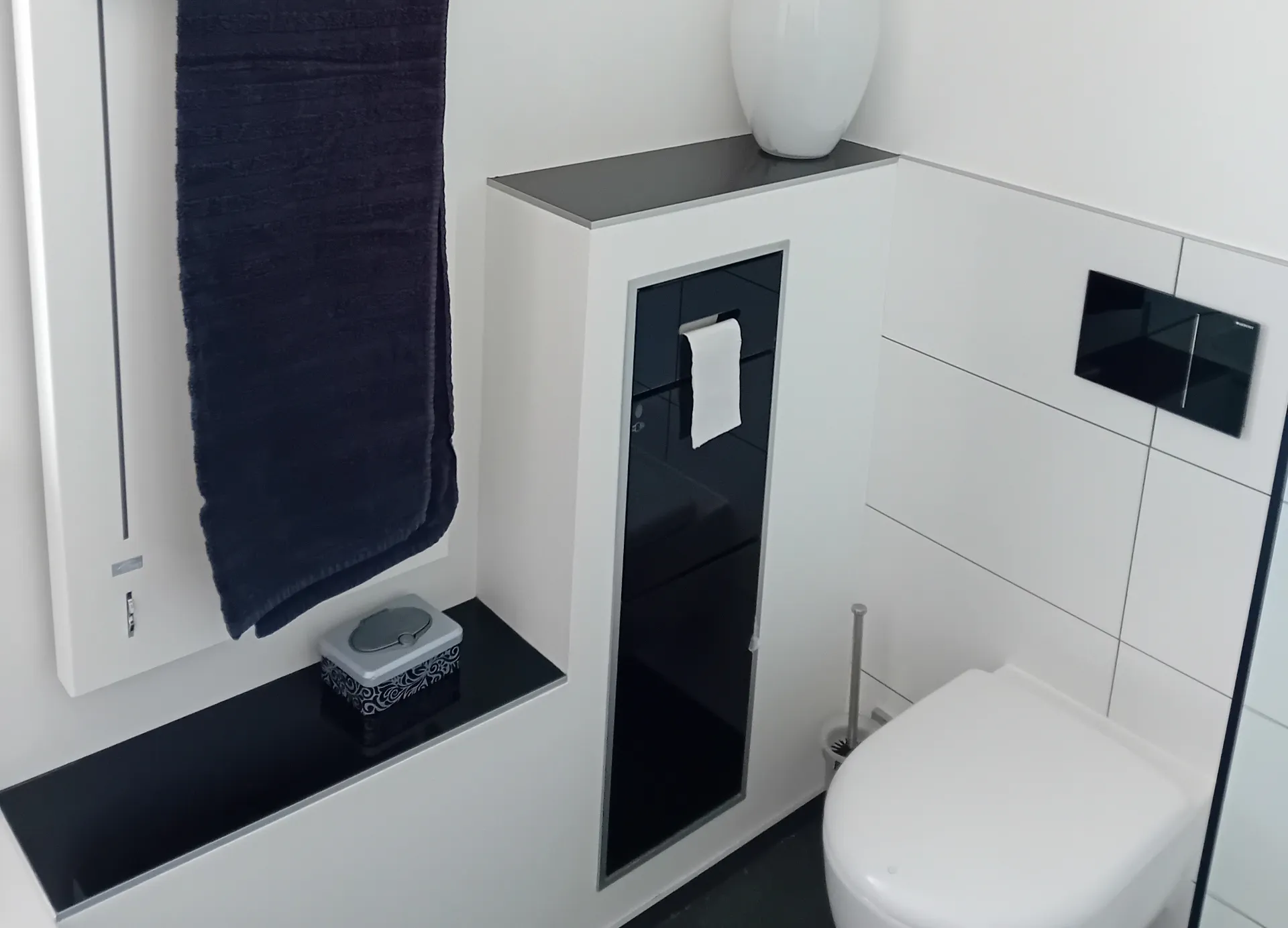 Schwarze Ablageflächen neben der Toilette