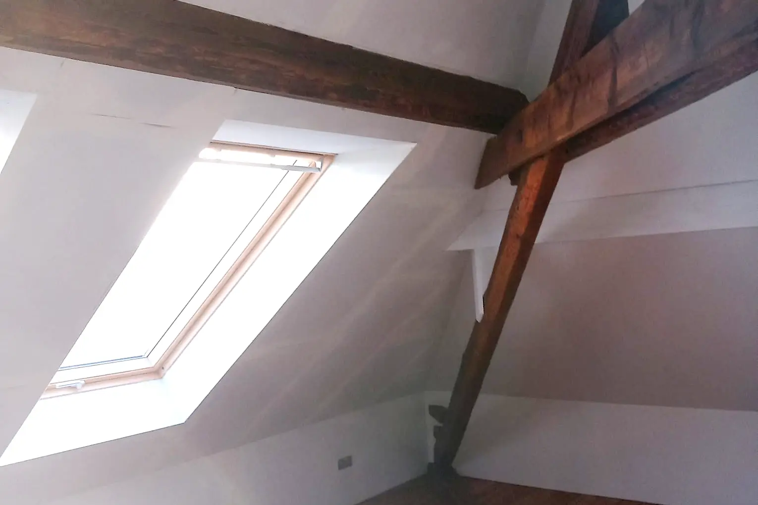 Dachfenster und geölte Balken