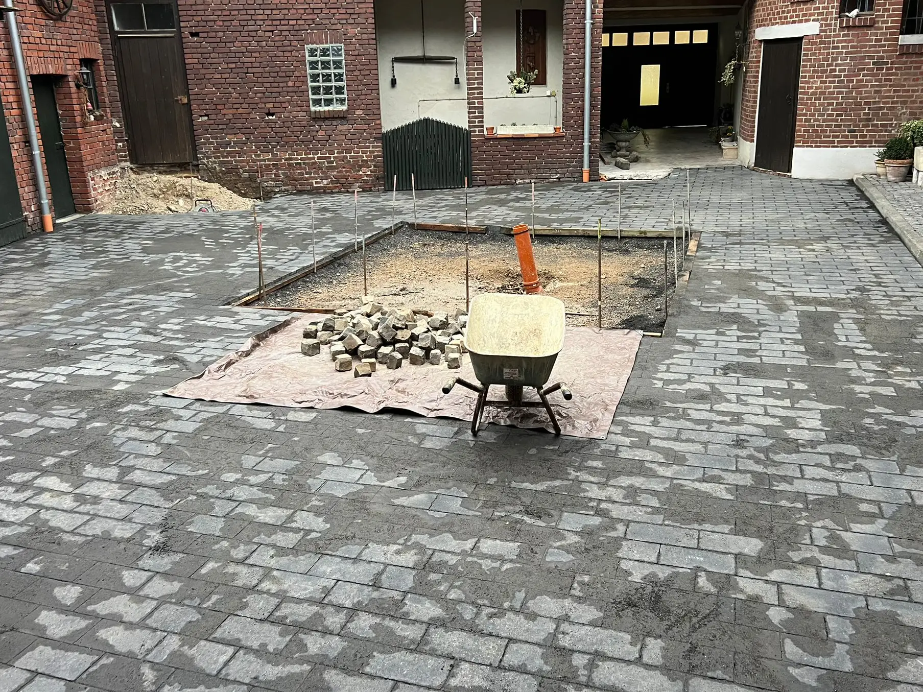 Arbeiten am Pflaster, Schubkarre im Vordergrund