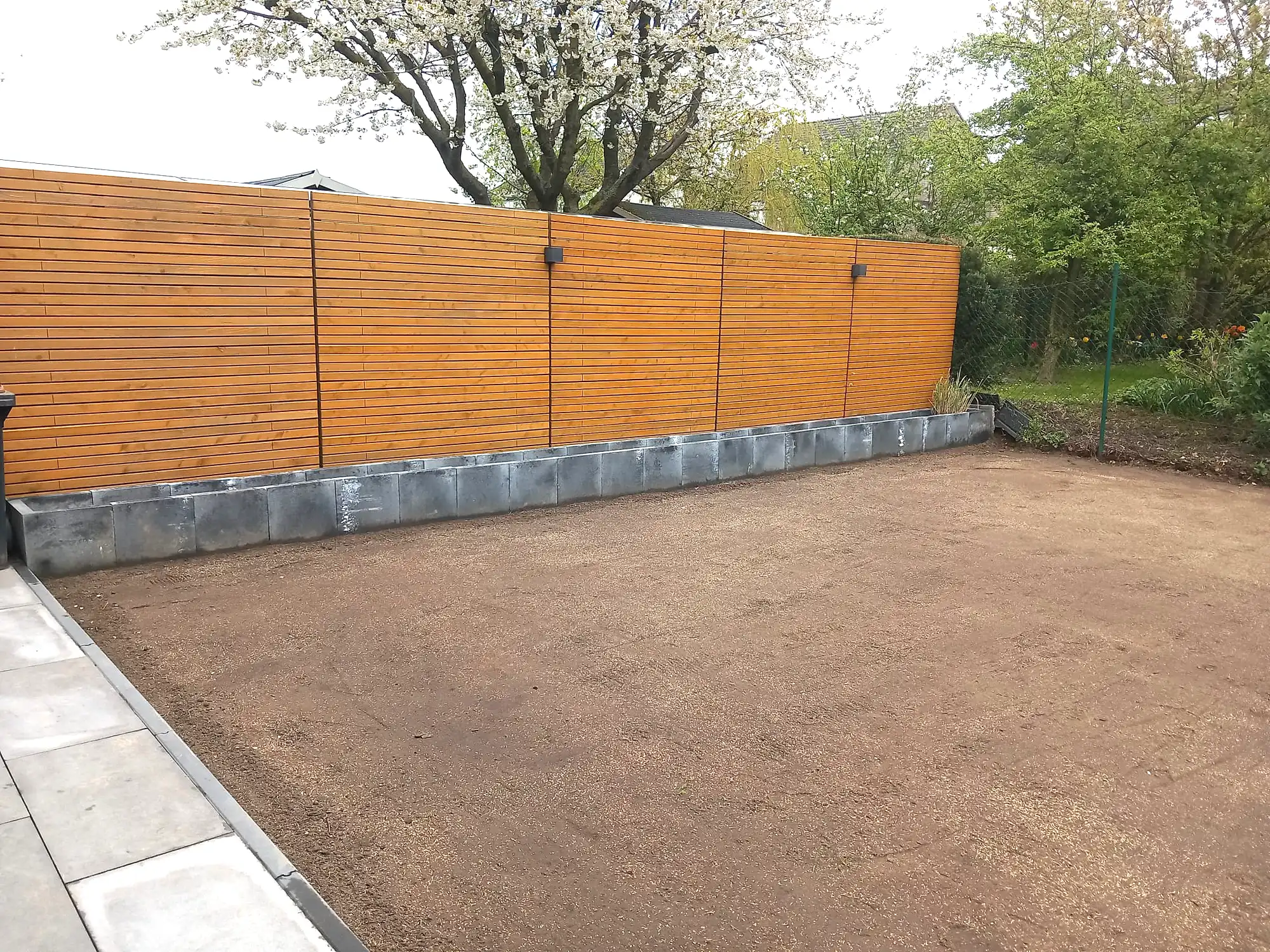 Gartenzaun und gerade gesetzte Pflanzkübel